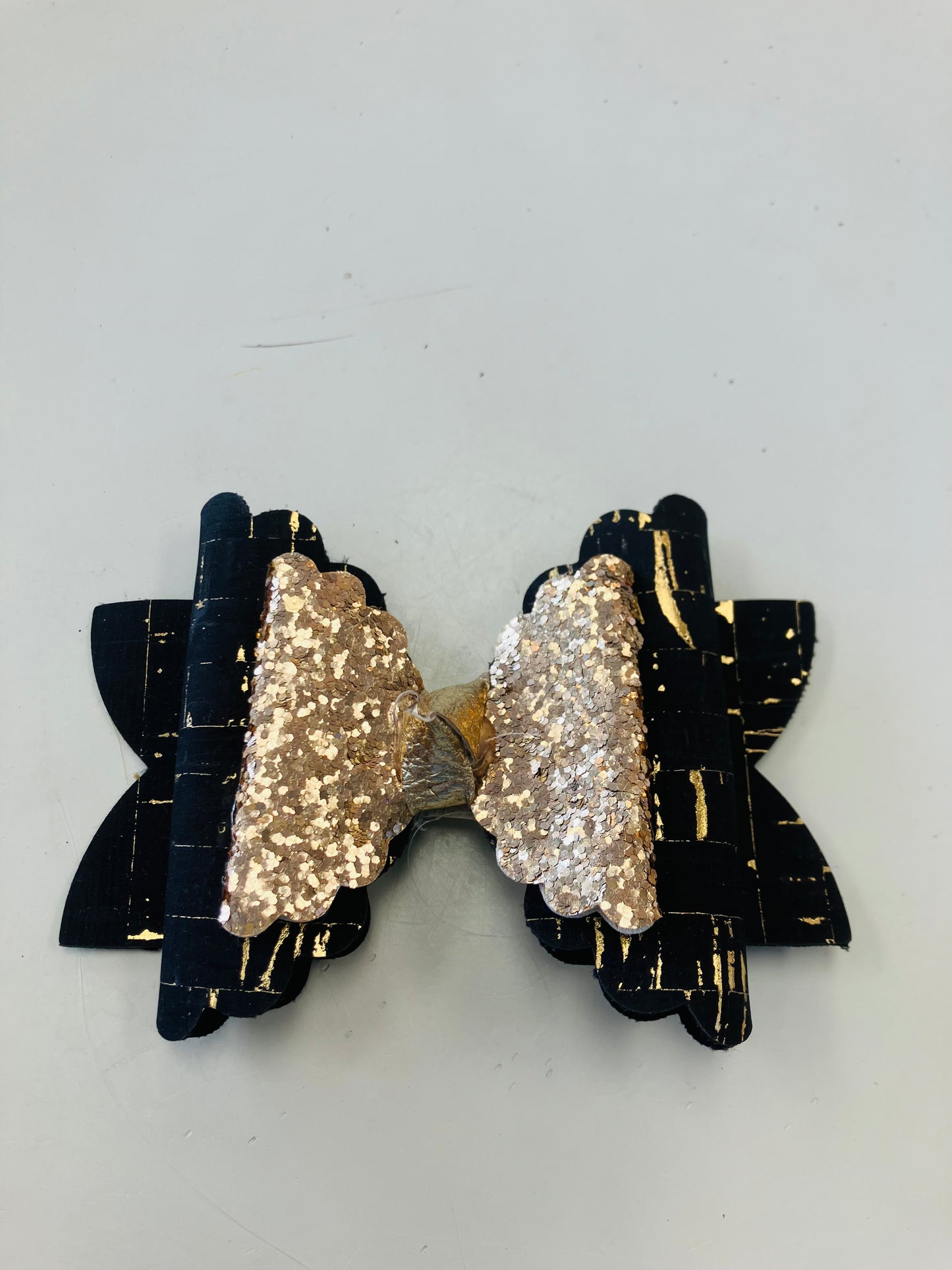 Medium black and metallic gold paint splotch bow